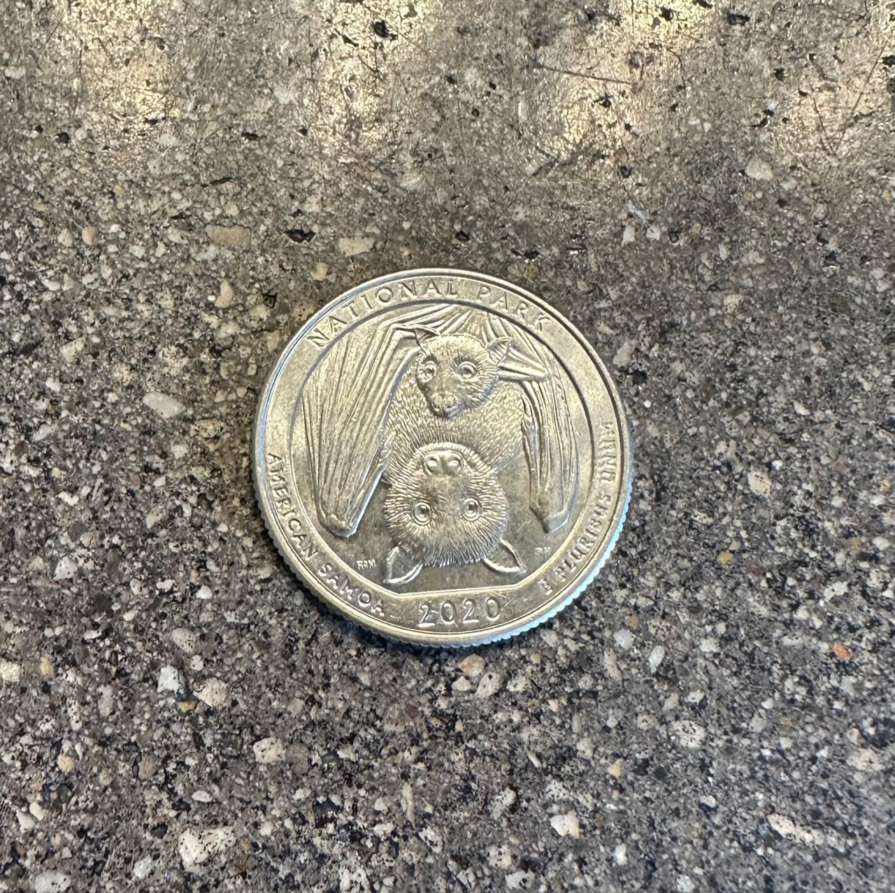 U.S. American Samoa National Park US Quarter Coin back on a concrete background.