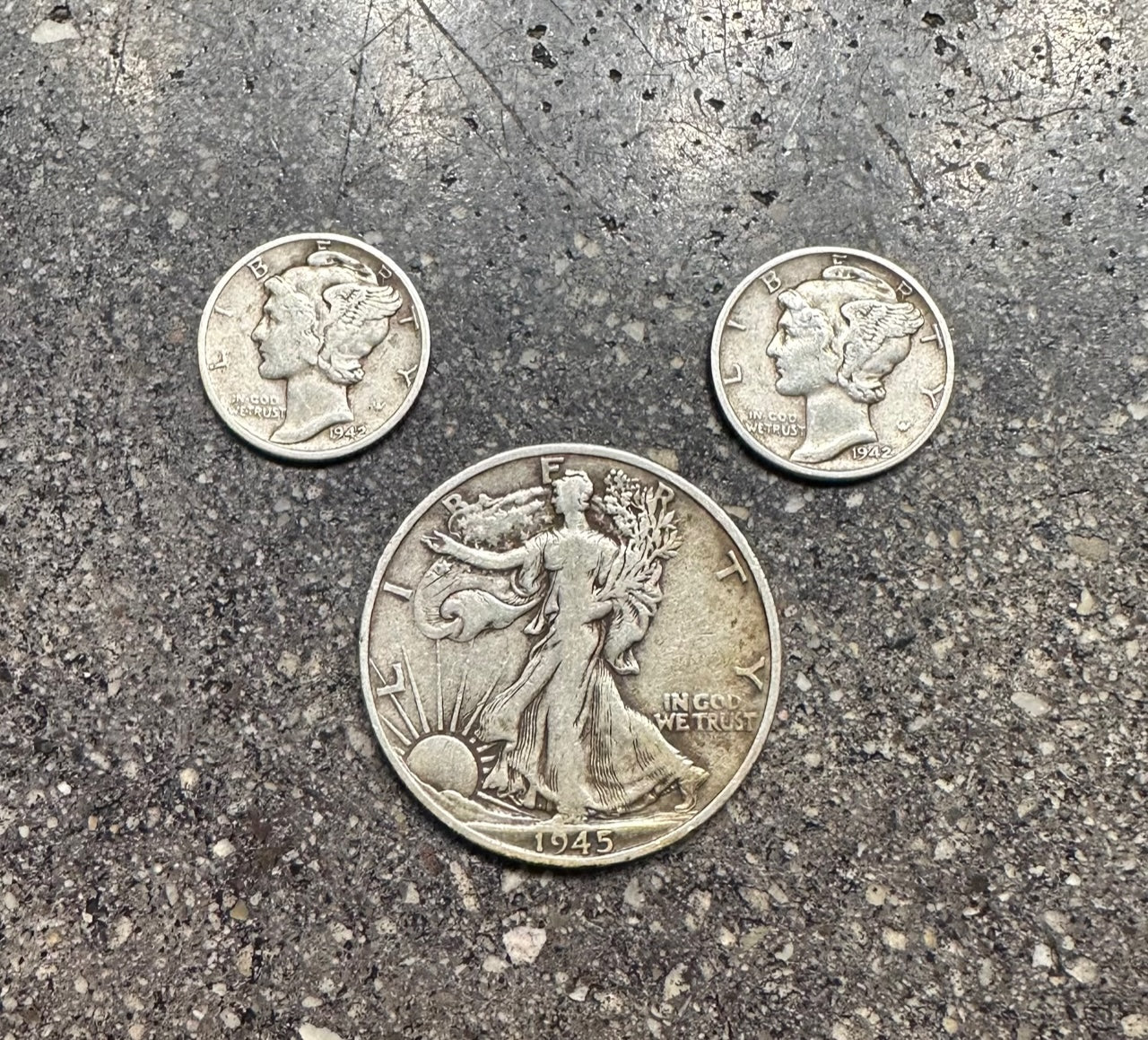 U.S. Mercury Dimes & Walking Liberty front of coins on concrete background.