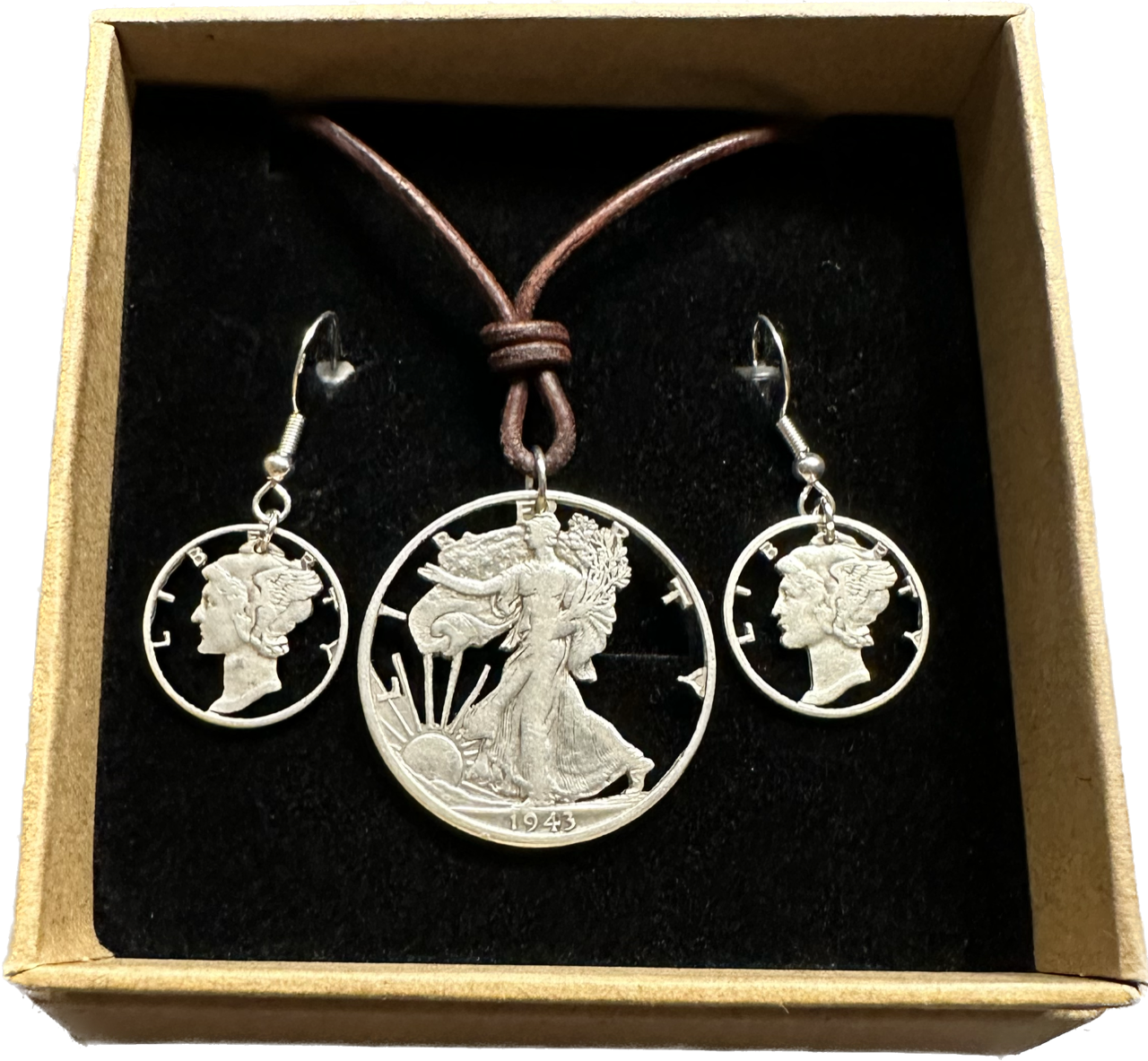 U.S. Lady Liberty Silver Hand Cut Coin Collection (leather cord) in a brown kraft box on a black velvet background.