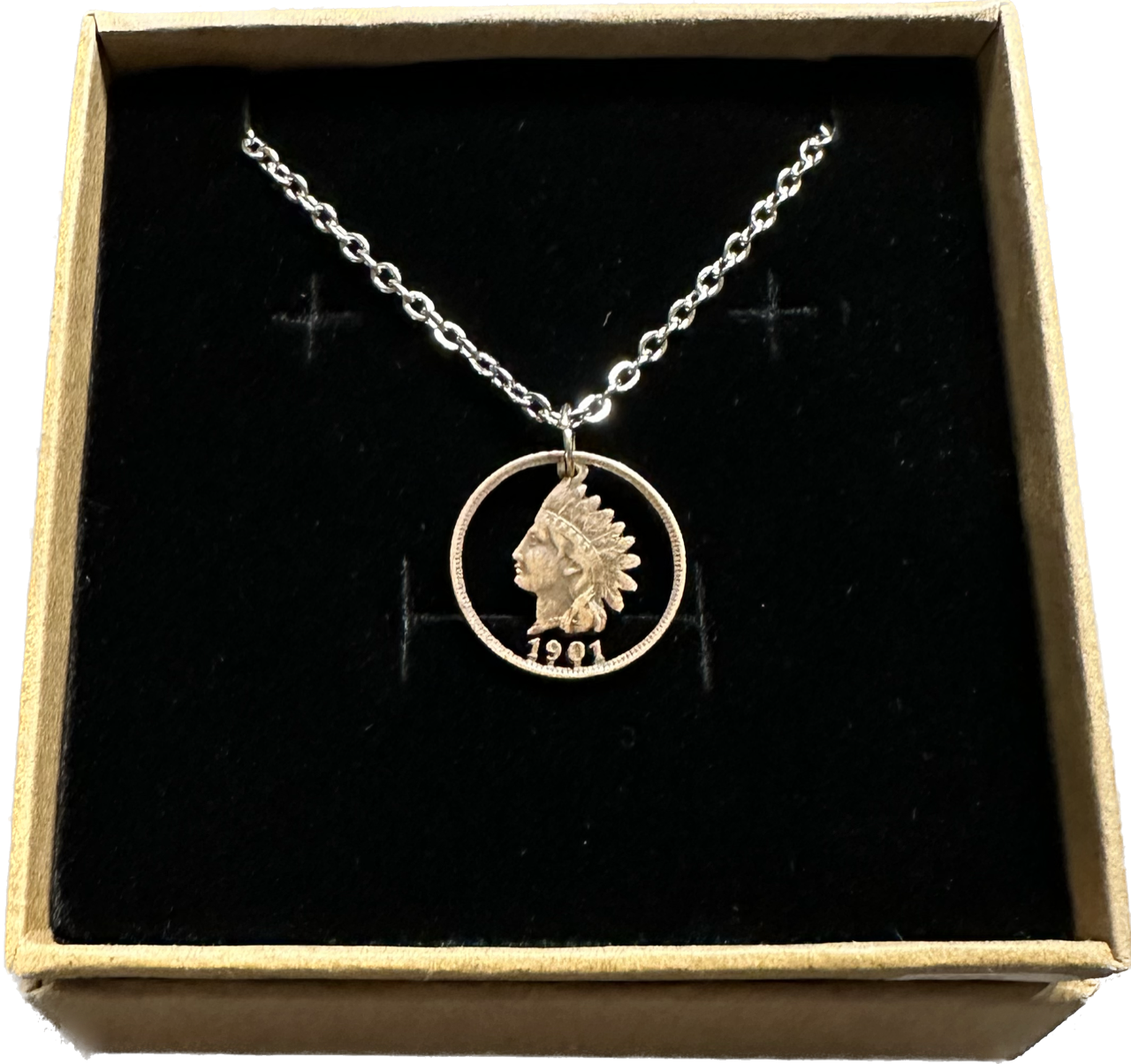 U.S. Indian Head Penny Coin Necklace with a stainless chain in a brown kraft box on a black velvet background.