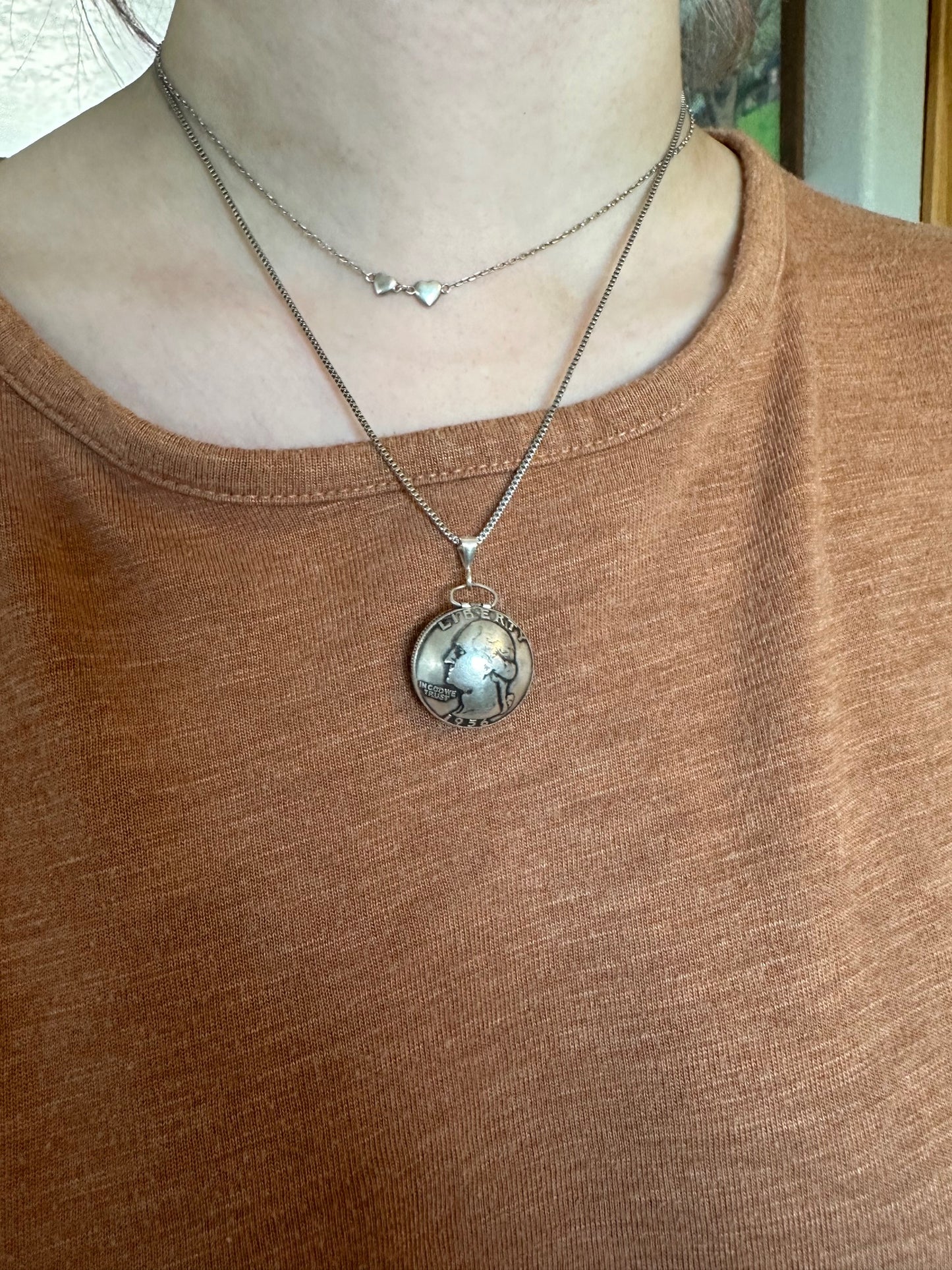 U.S. Silver Quarter Hand Crafted Coin Locket Necklace on a person with a tan/orange shirt.