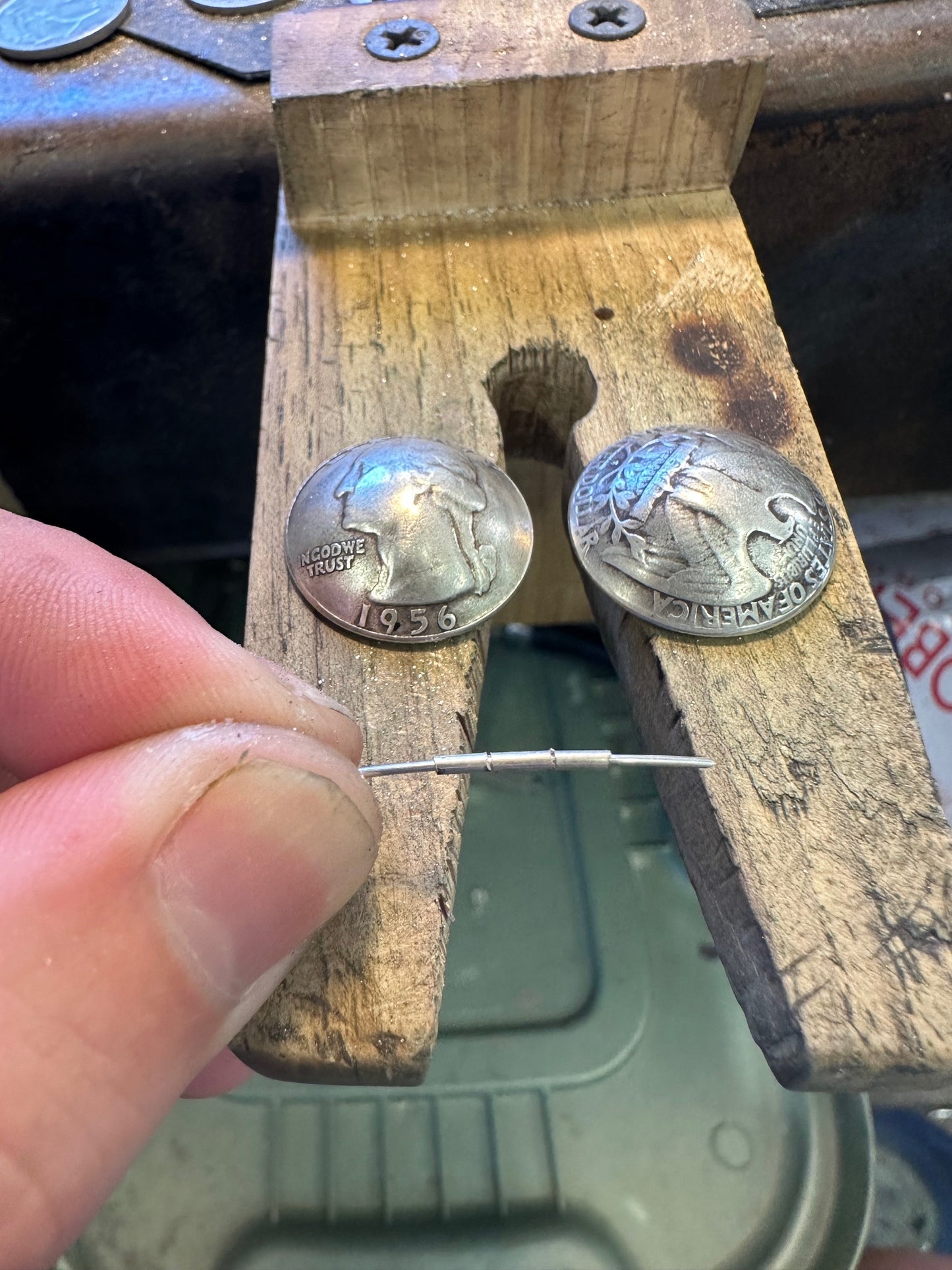 U.S. Silver Quarter Hand Crafted Coin Locket Necklace in the crafting process on a wooden block.