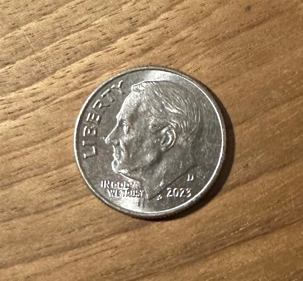 Dime Coin front on a wood background.
