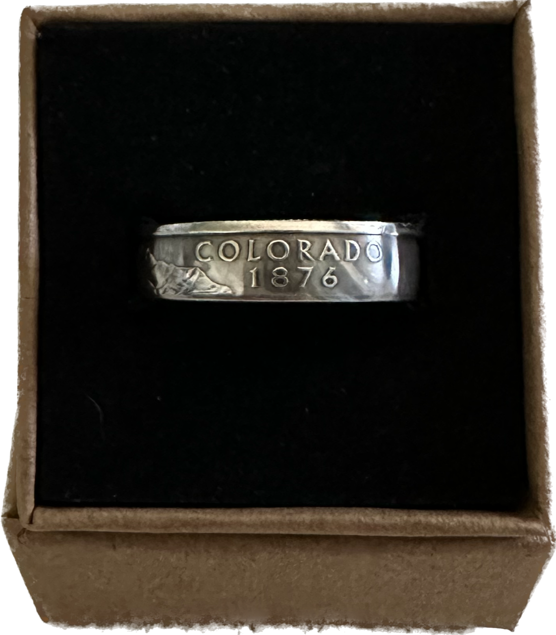 U.S. Silver State Quarter Coin Ring featuring Colorado in a brown kraft box on a black velvet background.