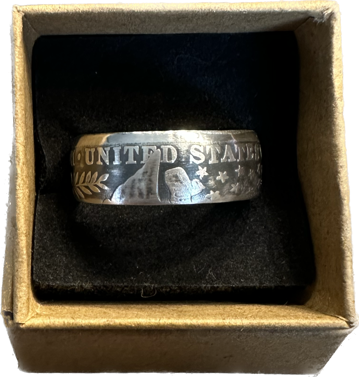 Barber Half Dollar Silver Coin Ring (reverse) in brown kraft box on a black velvet background.
