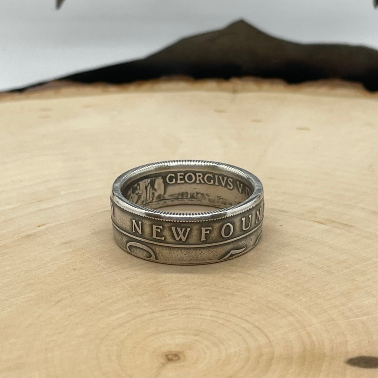 Newfoundland 50 Cents Silver Coin Ring on a light wood round.