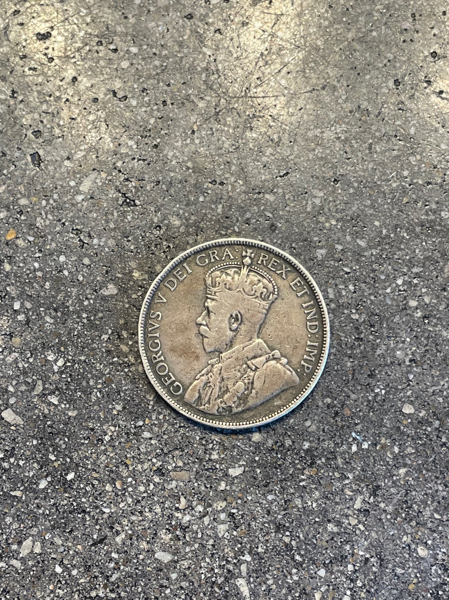 Newfoundland 50 Cents Silver Coin front on a concrete background.