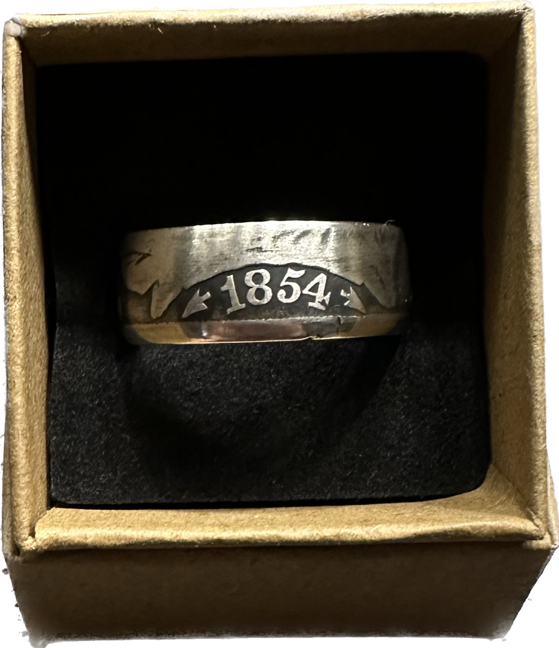 Seated Liberty Silver Half Dollar Coin Ring (patina) in a brown kraft box on a black velvet background.