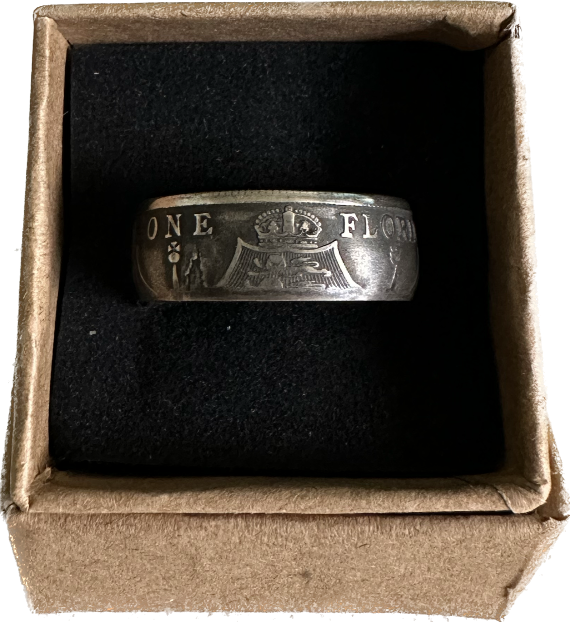UK One Florin Silver Coin Ring in a brown kraft box on a black velvet background.