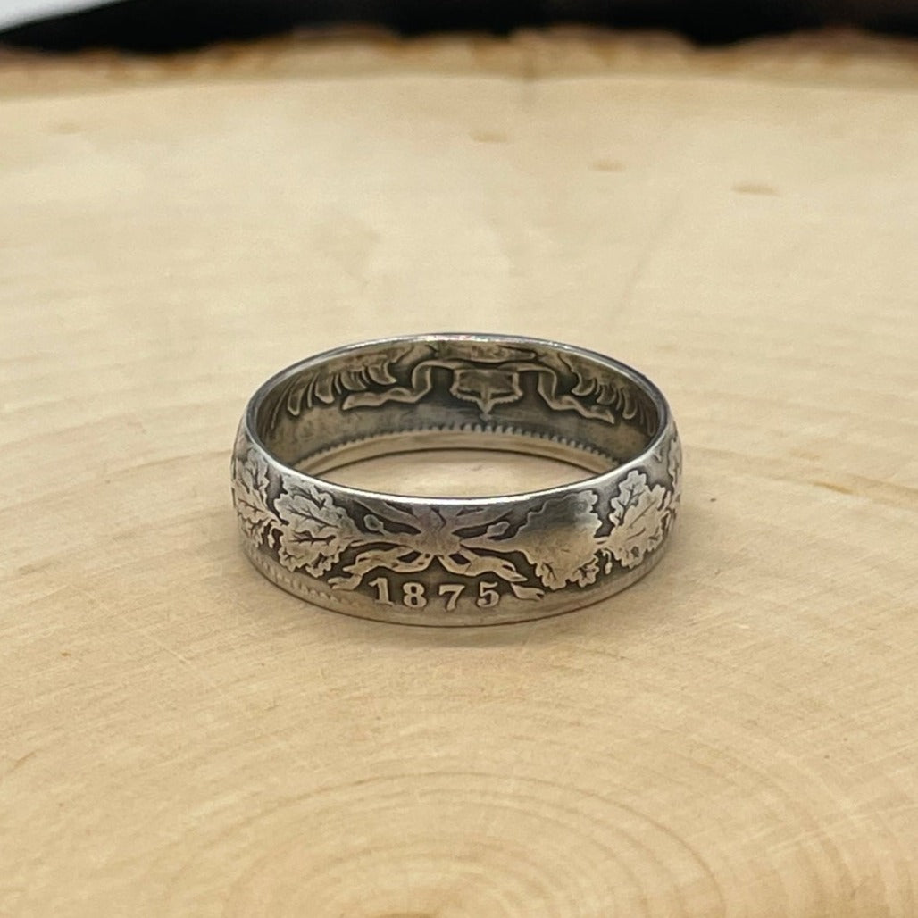 Germany 1 Mark Silver Coin Ring on a light wood round.