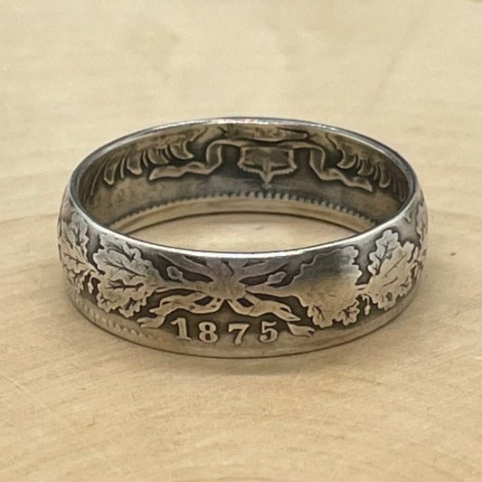 Germany 1 Mark Silver Coin Ring on a light wood round.