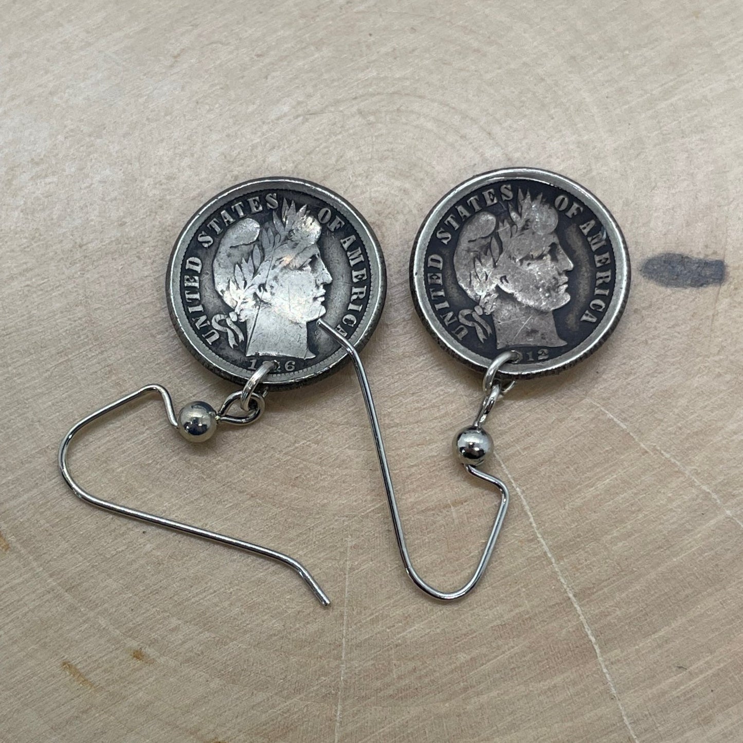 U.S Barber Dime Silver Coin Earring backs on a light wood round. - Mountainstruck Coin Jewelry