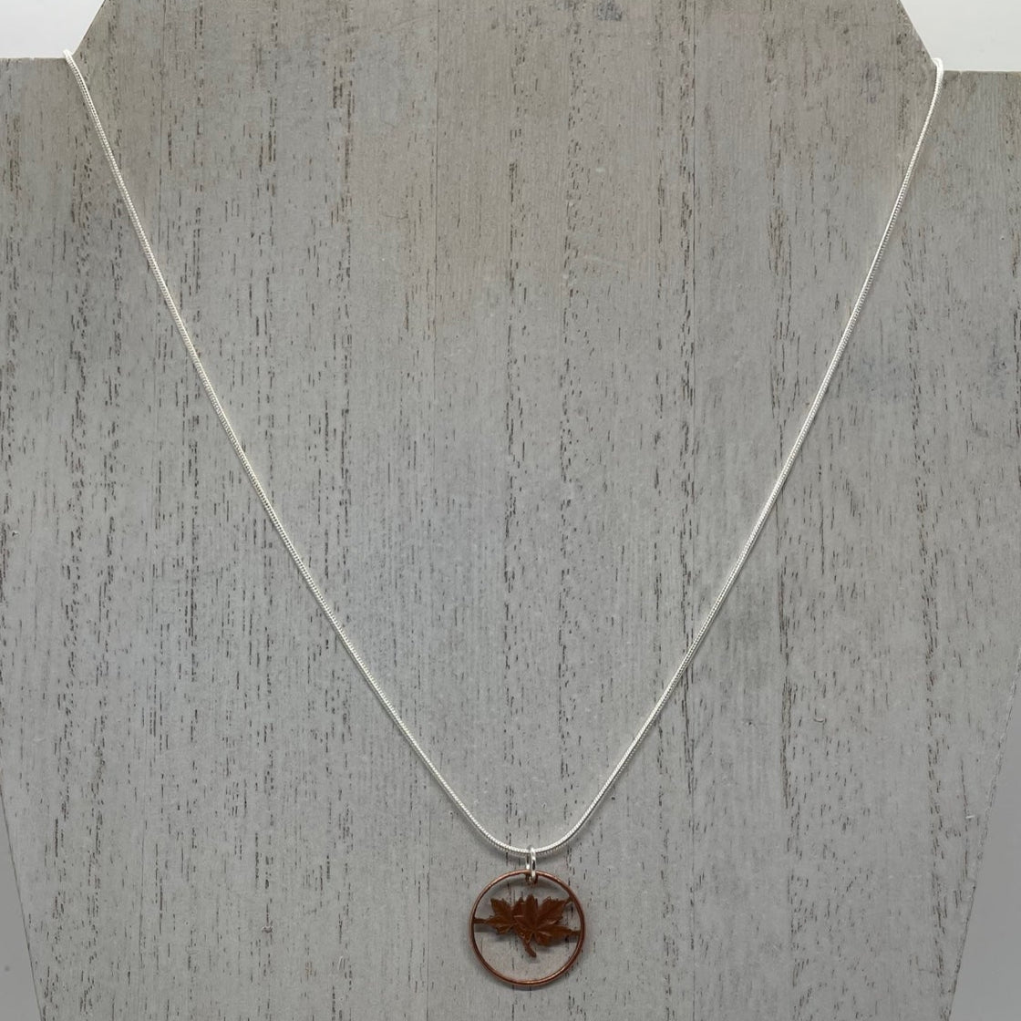 Canada Maple Leaf Penny Hand Cut Necklace on a white wood display. - Mountainstruck Coin Jewelry