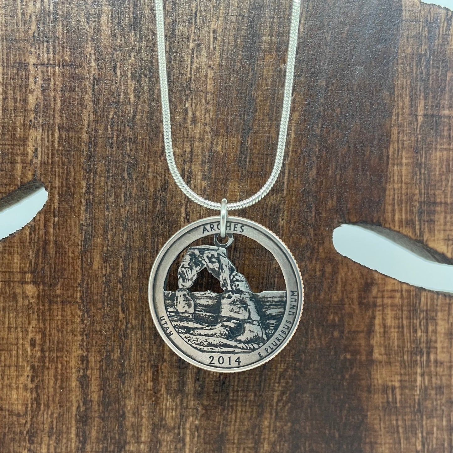U.S. Arches National Park Coin Necklace on a wooden tree background. - Mountainstruck Coin Jewelry