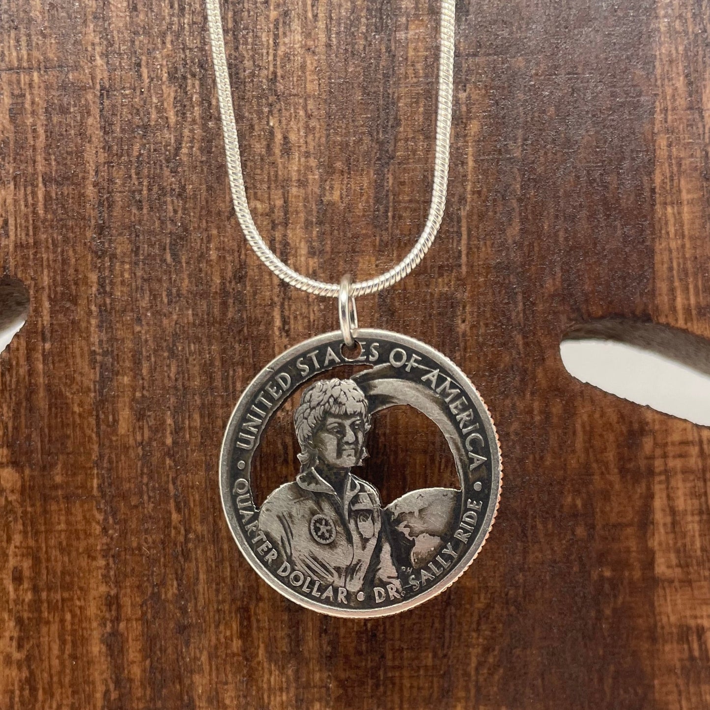U.S. First American Woman in Space Coin Necklace with a snake chain on a wood tree background. - Mountainstruck Coin Jewelry