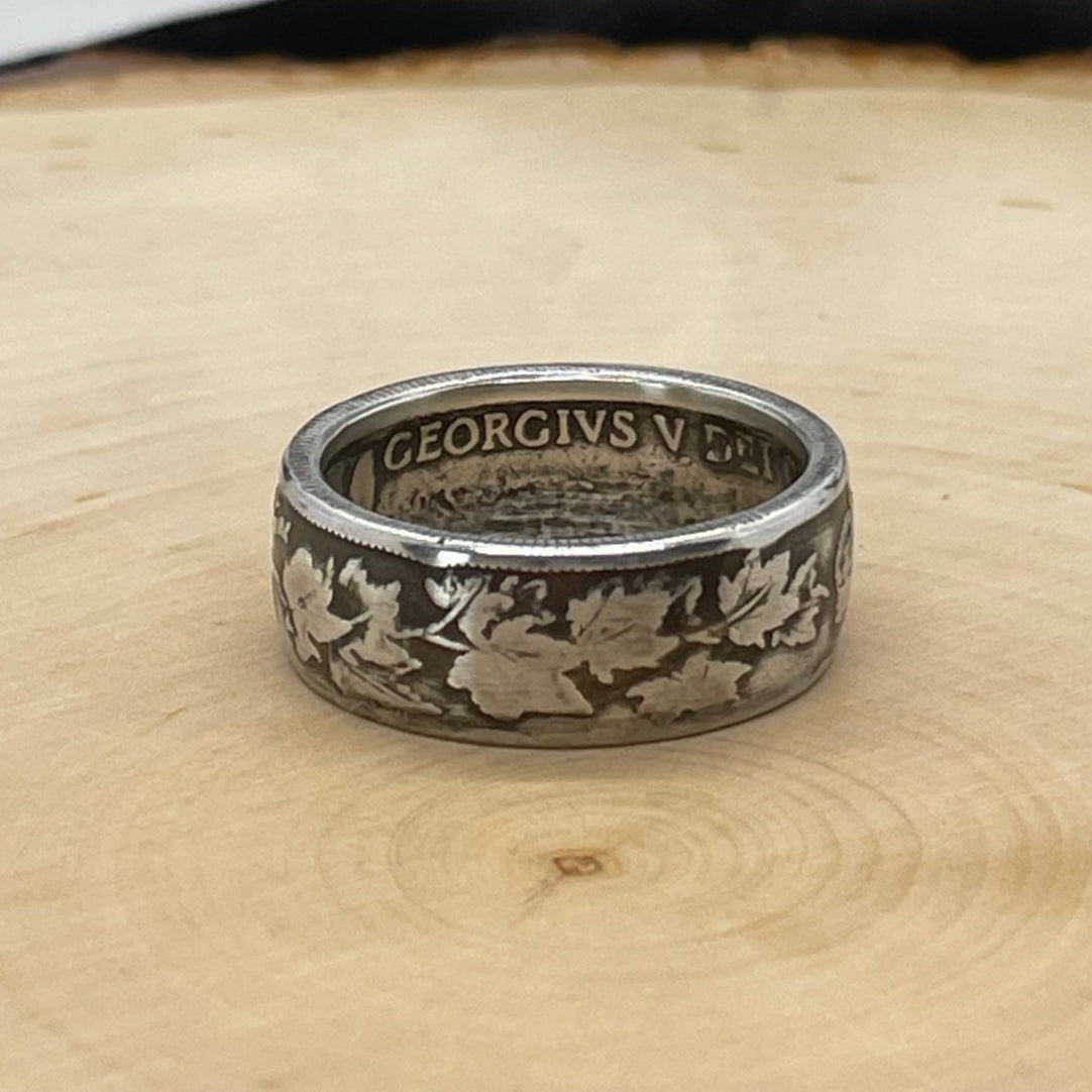 Canada 50 Cents Maple Leaf Silver Coin Ring on a light wood round with a mountain outline background. - Mountainstruck Coin Jewelry