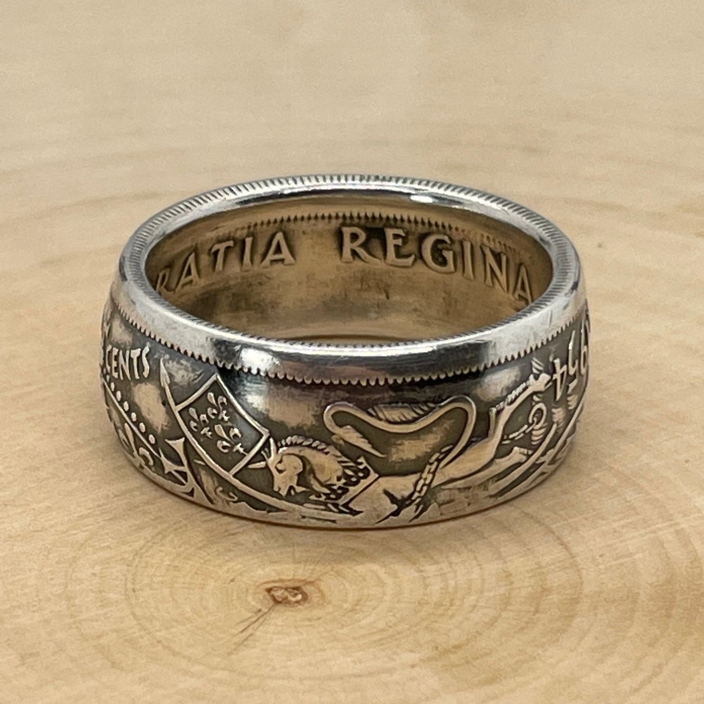 Canada 50 Cents Silver Coin Ring (Lion + Unicorn) on a light wood round. - Mountainstruck Coin Jewelry