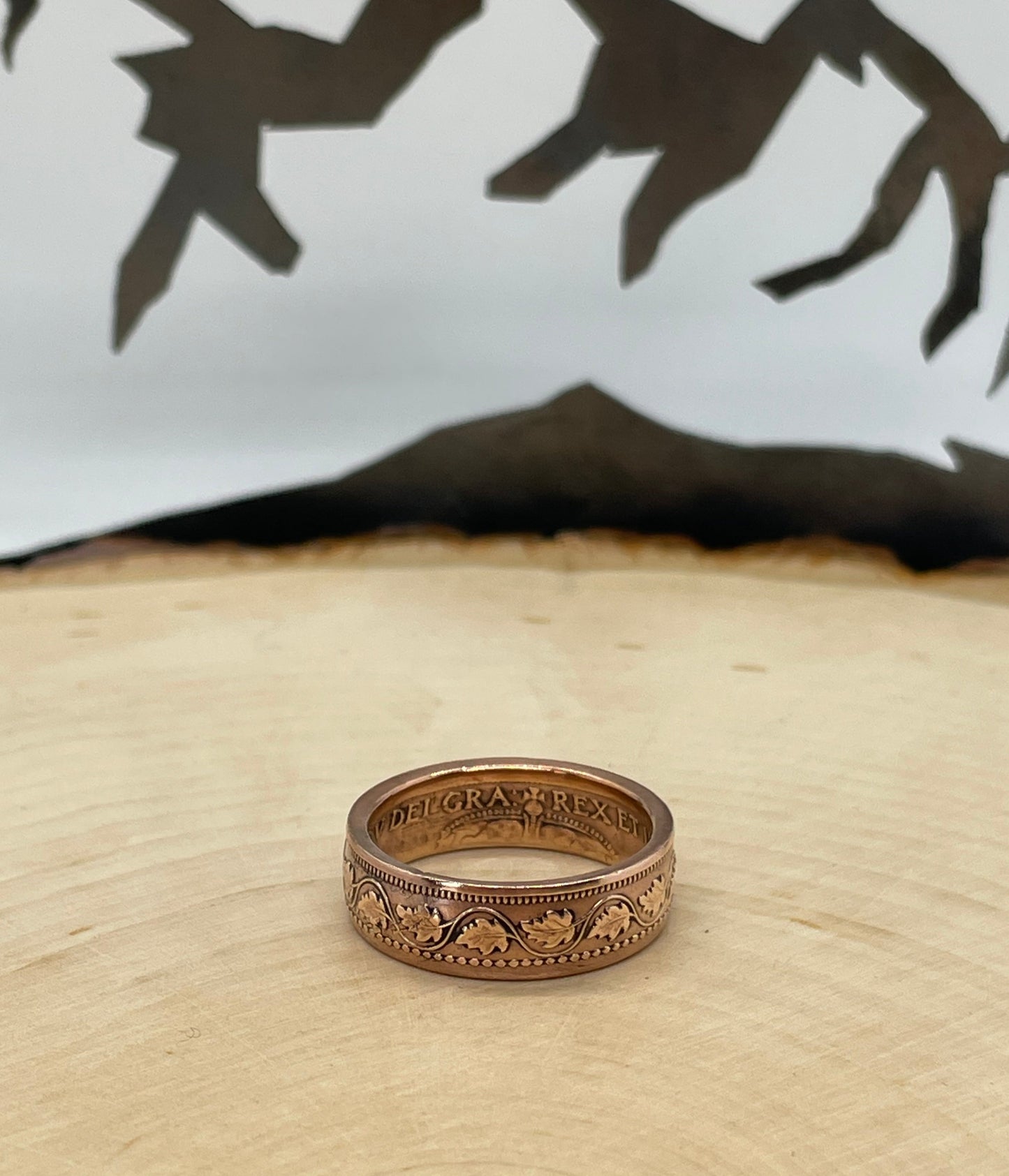Canada Large Cent Leaf Coin Ring on a light wood round with a mountain outline background. - Mountainstruck Coin Jewelry
