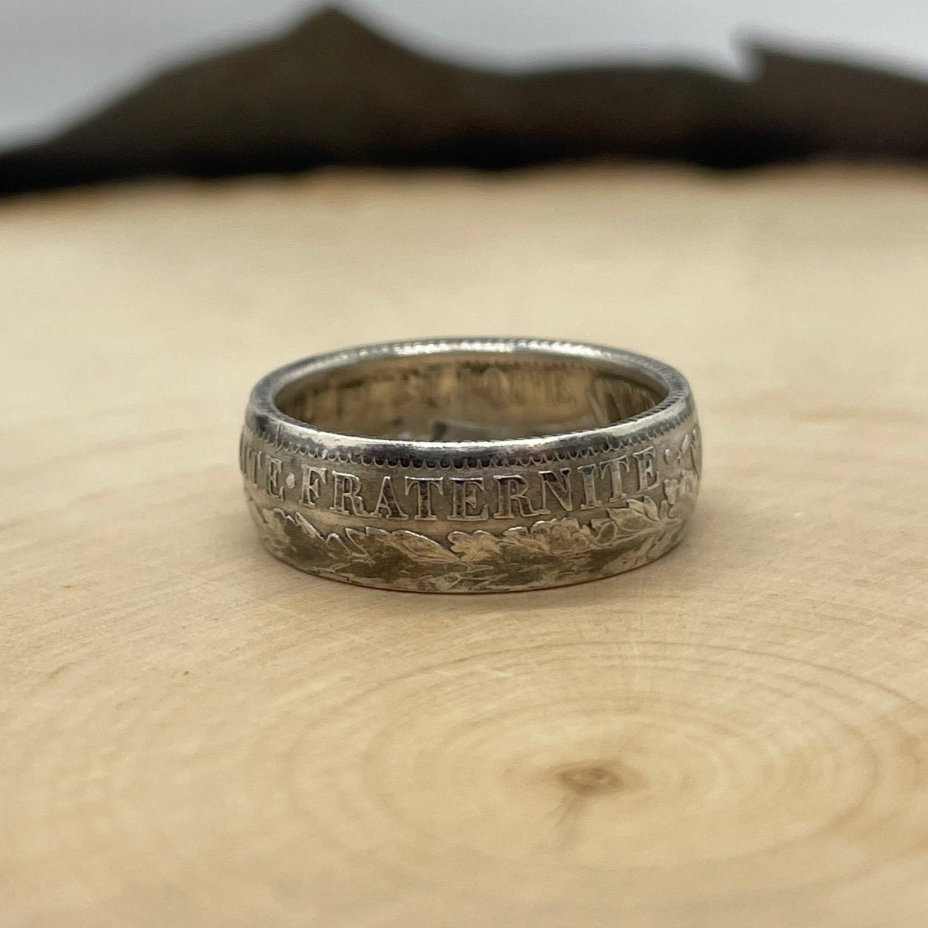 France 1 Franc Silver Coin Ring on a light wood round with a mountain outline background. - Mountainstruck Coin Jewelry