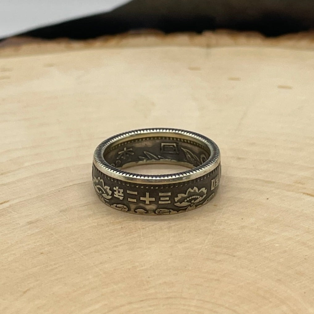 Japan 100 Yen Silver Coin Ring on a light wood round. - Mountainstruck Coin Jewelry