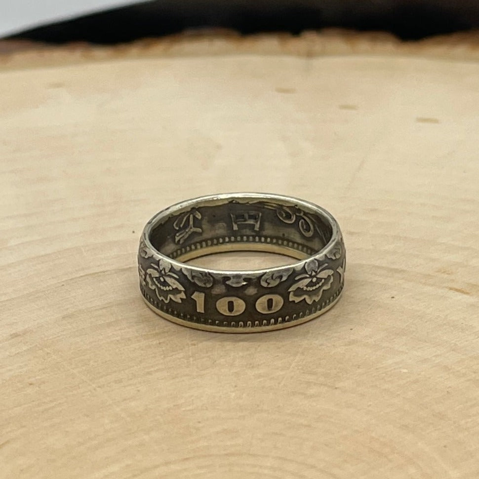 Japan 100 Yen Silver Coin Ring on a light wood round. - Mountainstruck Coin Jewelry