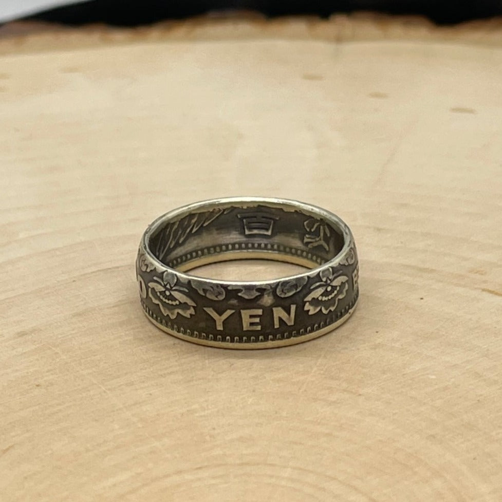 Japan 100 Yen Silver Coin Ring on a light wood round. - Mountainstruck Coin Jewelry