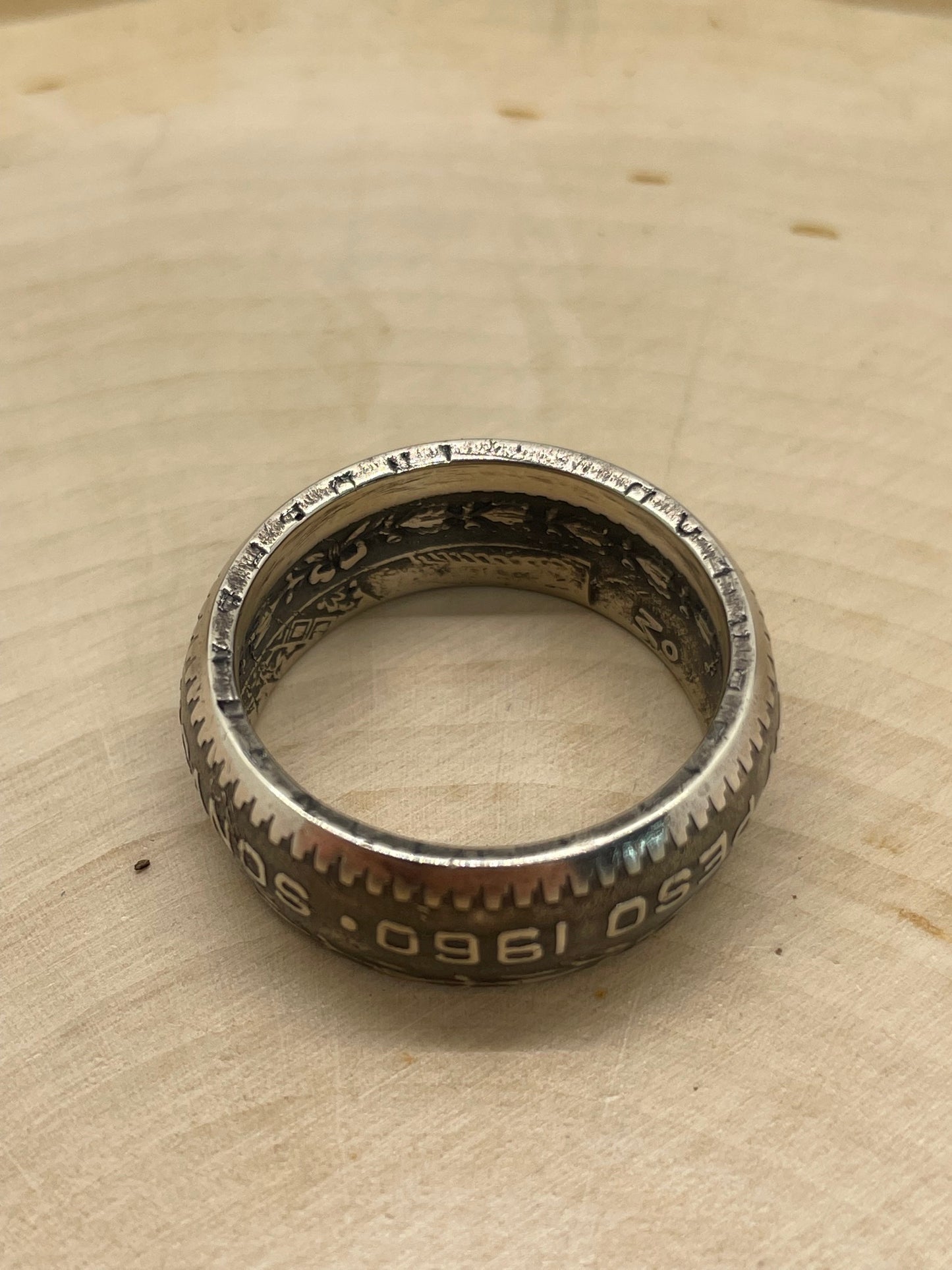 Mexico Silver Peso Coin Ring showing inscription on edge of coin on a light wood round. - Mountainstruck Coin Jewelry