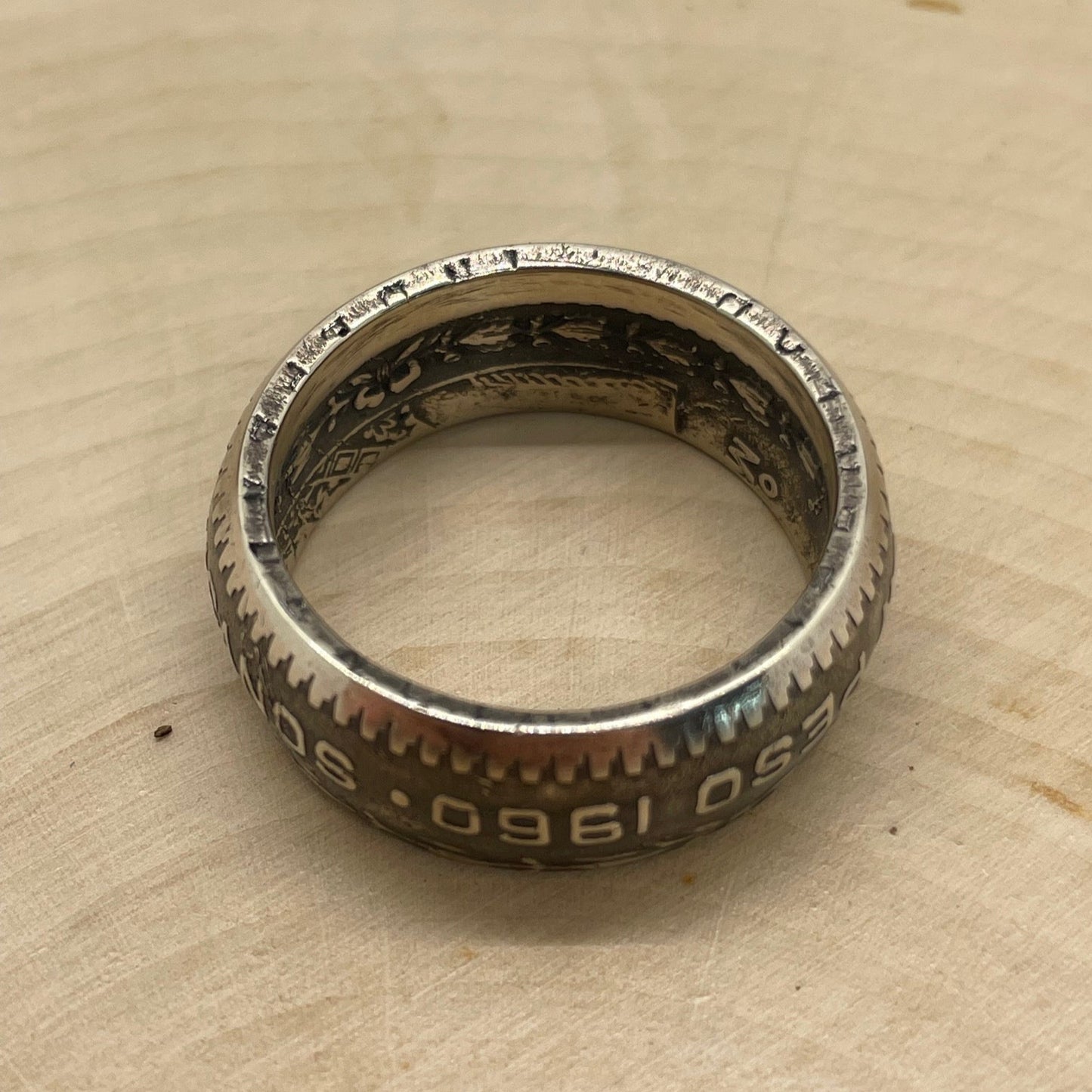 Mexico Silver Peso Coin Ring showing inscription on edge of coin on a light wood round. - Mountainstruck Coin Jewelry