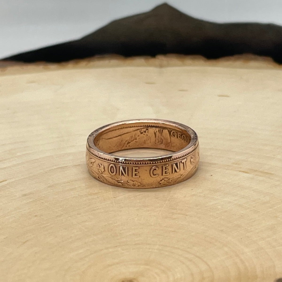 Newfoundland 1 Cent Coin Ring on a light wood round. - Mountainstruck Coin Jewelry