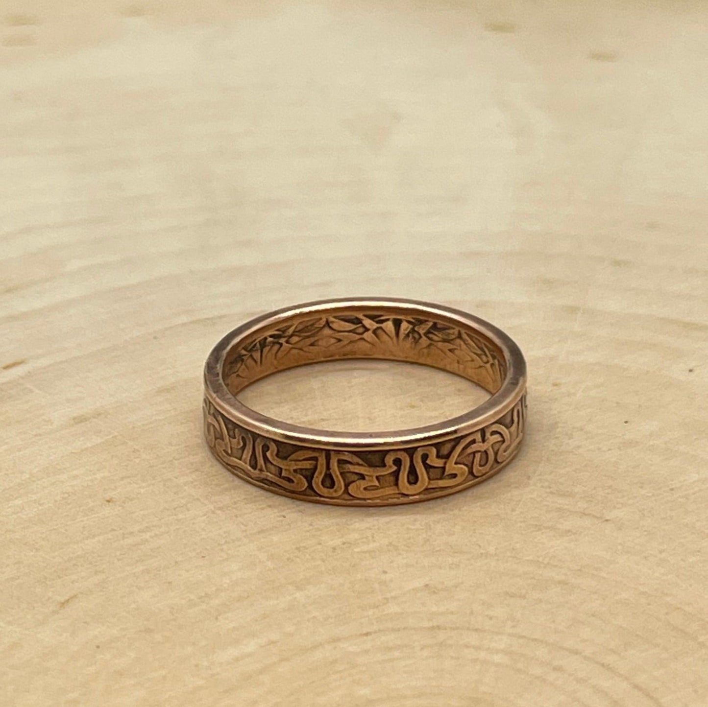 Suriname 1 Cent Coin Ring on a light wood round. - Mountainstruck Coin Jewelry
