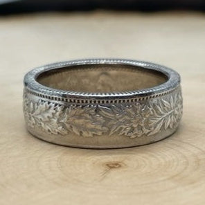 Swiss 2 Franc Silver Coin Ring (shine) on a light wood round with mountain outline in the background. - Mountainstruck Coin Jewelry
