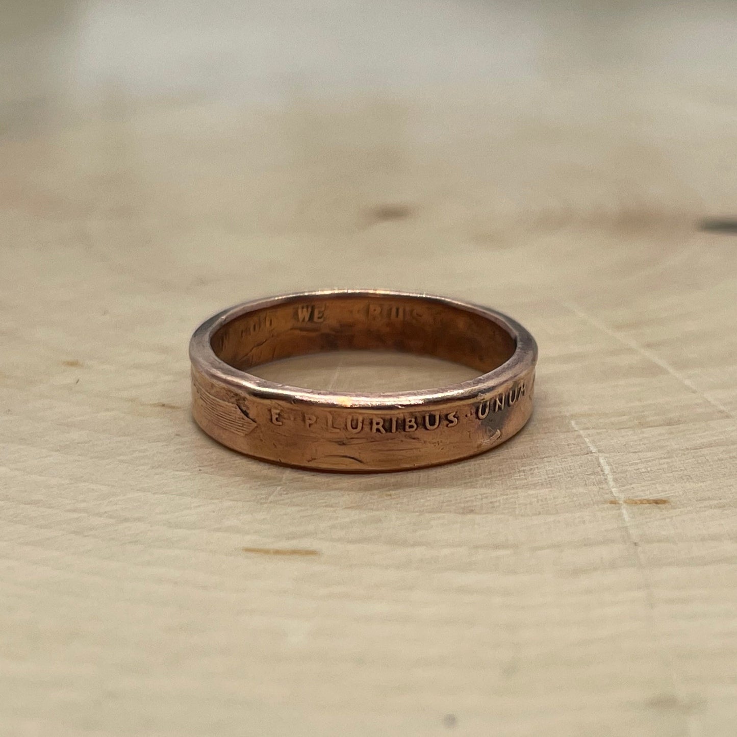 Wheat Penny Coin Ring on a light wood round.
