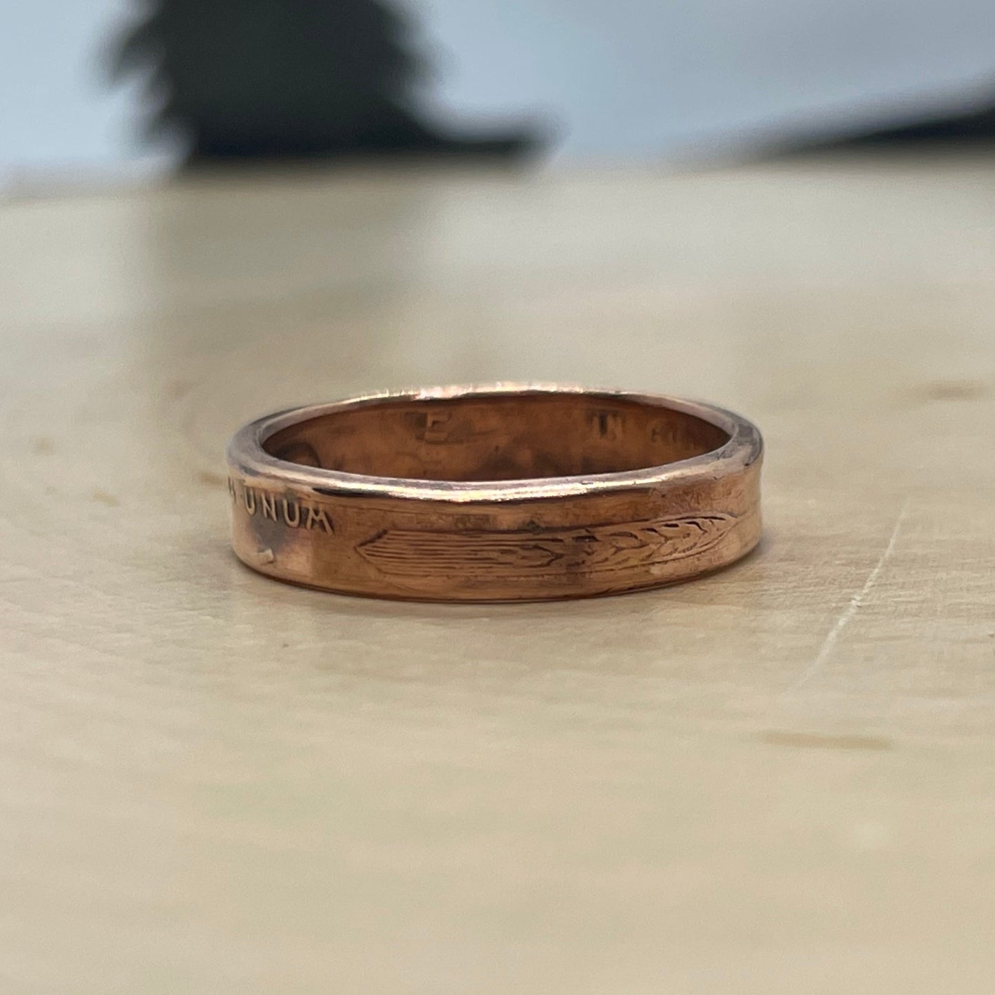 Wheat Penny Coin Ring on a light wood round.