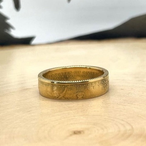 U.S. Gold Eagle 1/4 oz Fine Gold Coin Ring on a light wood background.