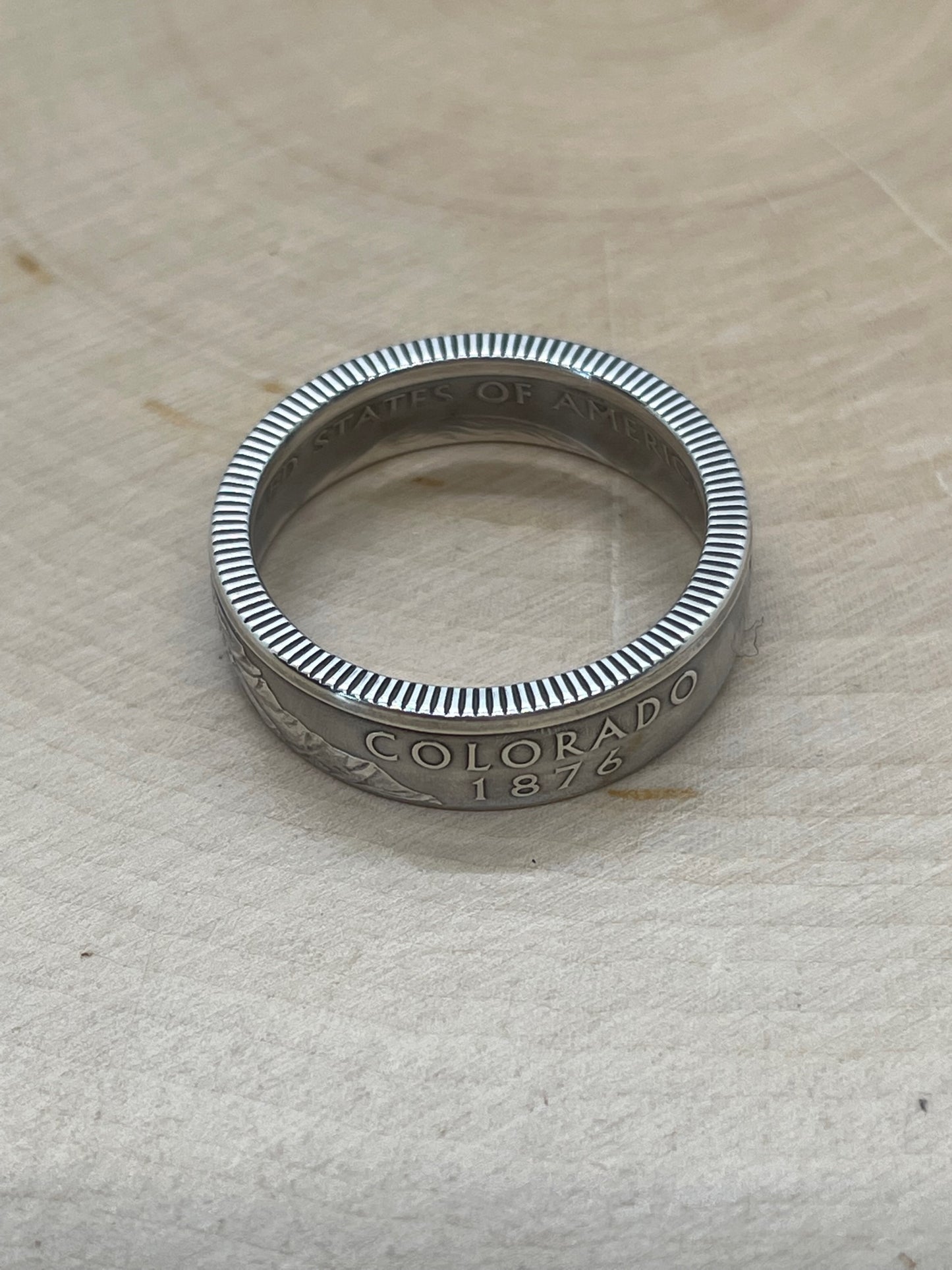 U.S. Silver State Quarter Coin Ring featuring Colorado on a light wood round.