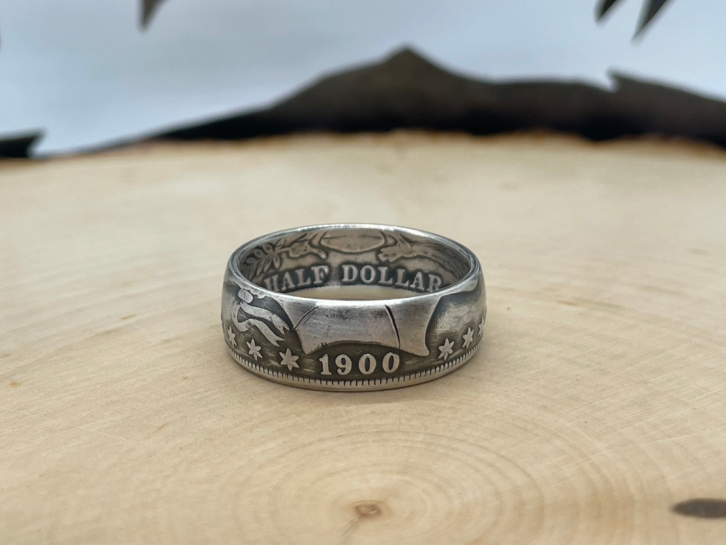 Barber Silver Half Dollar Coin Ring (front) on a light wood background.