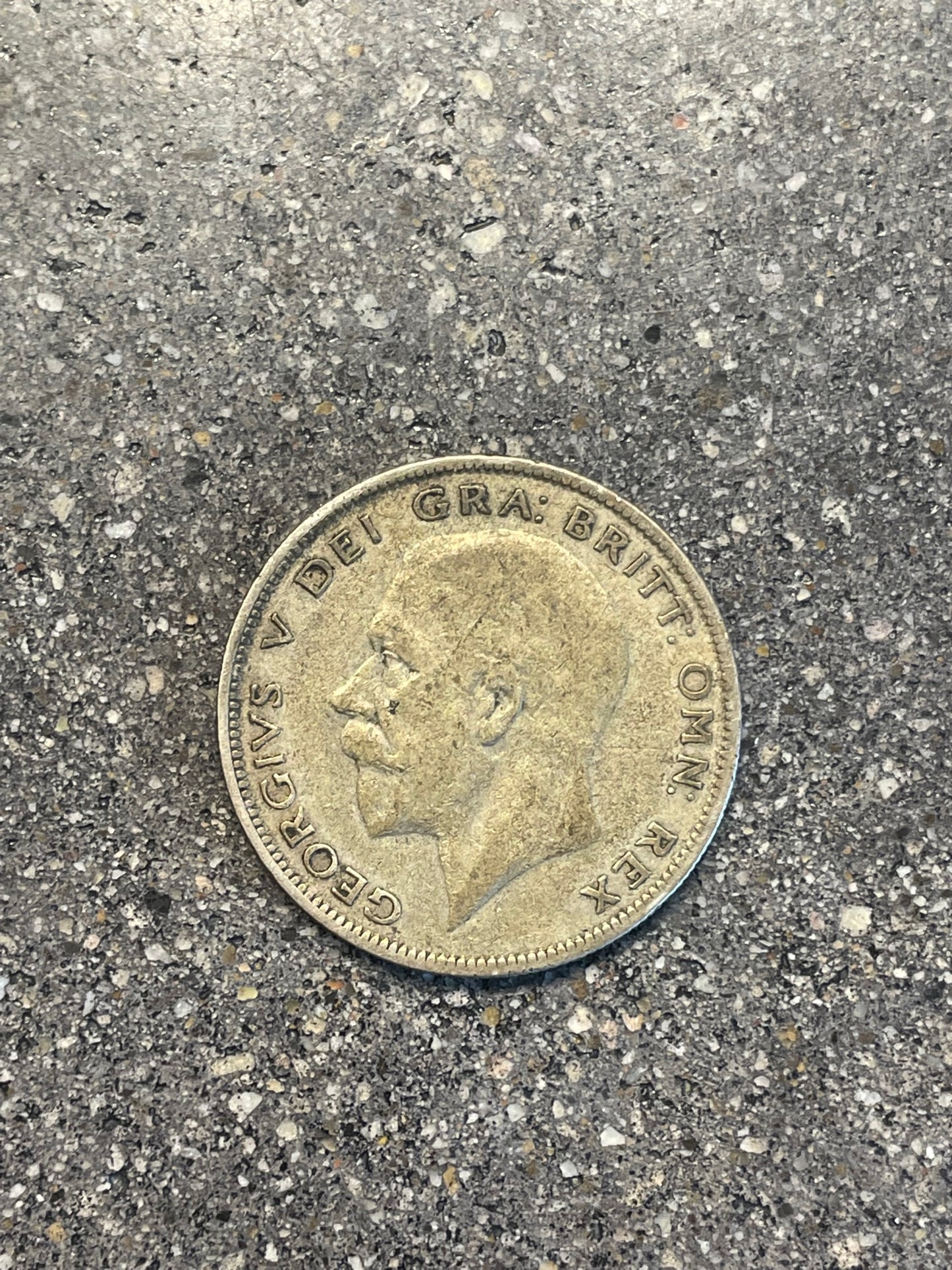 UK Half Crown Silver Coin front on a concrete background.