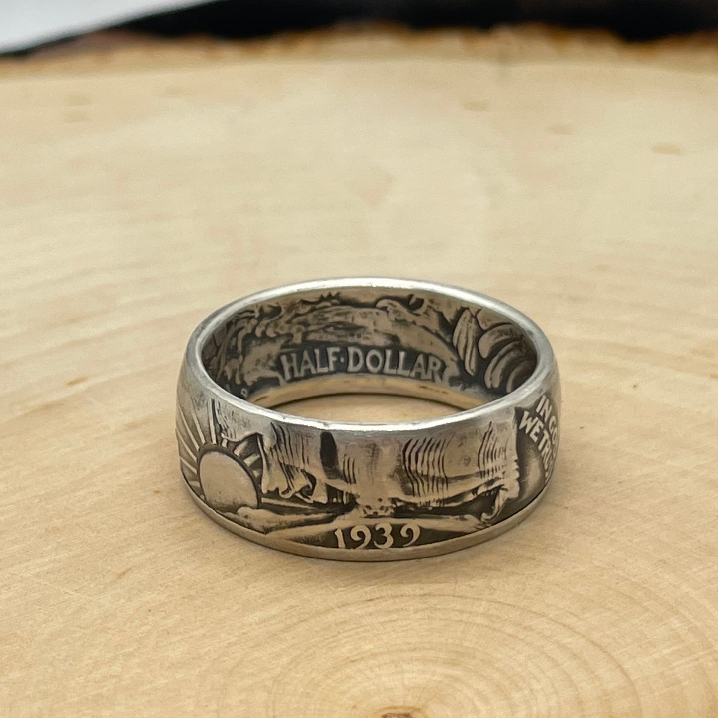 Walking Liberty Silver Half Dollar Coin Ring on a light wood round.