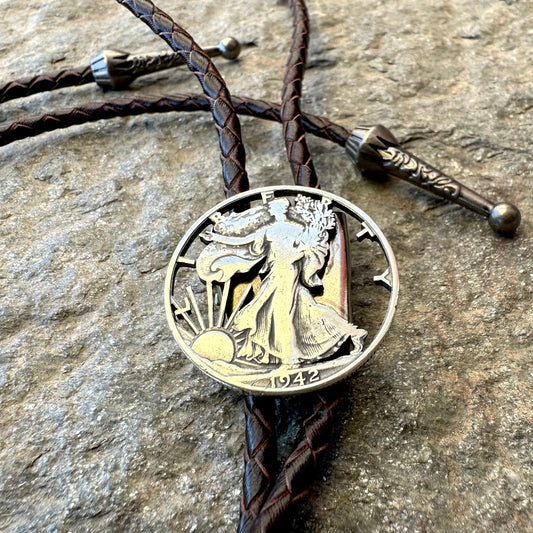 U.S. Walking Liberty Half Dollar Hand Cut Silver Coin Bolo Tie on a grey rock surface. - Mountainstruck Coin Jewelry