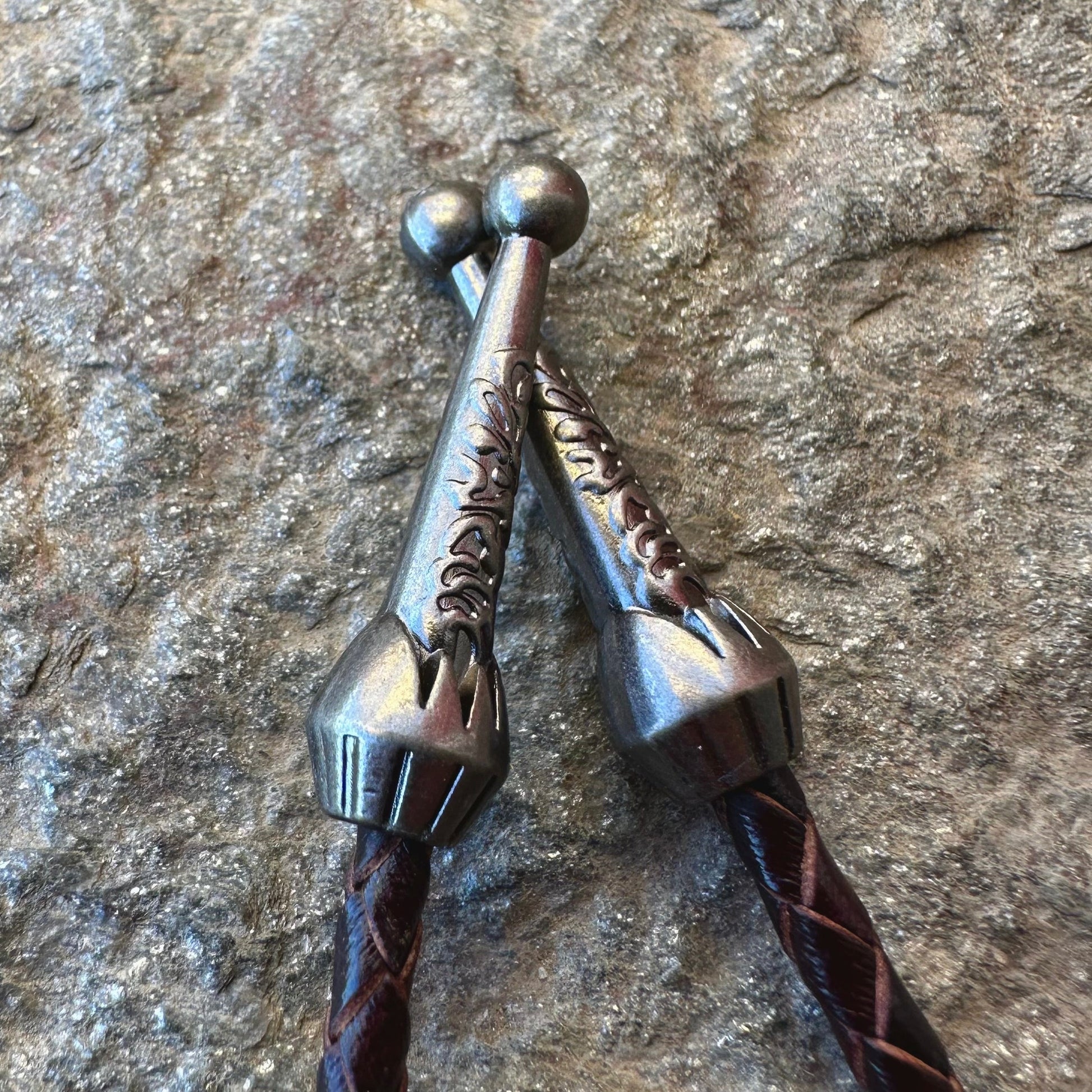 U.S. Walking Liberty Half Dollar Hand Cut Silver Coin Bolo Tie pewter ends on a grey rock surface. - Mountainstruck Coin Jewelry