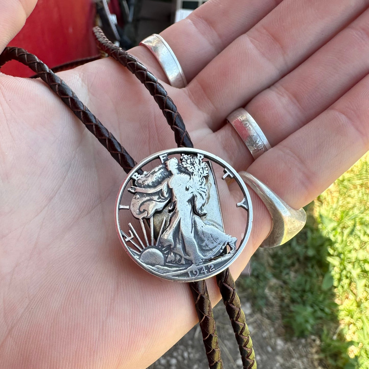 U.S. Walking Liberty Half Dollar Hand Cut Silver Coin Bolo Tie on a hand. - Mountainstruck Coin Jewelry