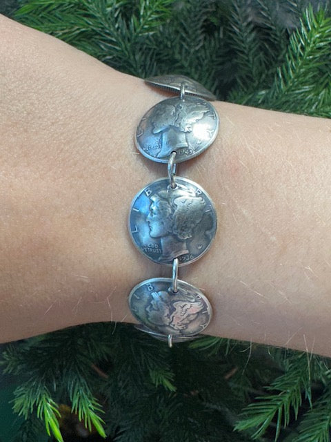 U.S. Mercury Dime Silver Coin Bracelet on a wrist in front of a pine tree. - Mountainstruck Coin Jewelry