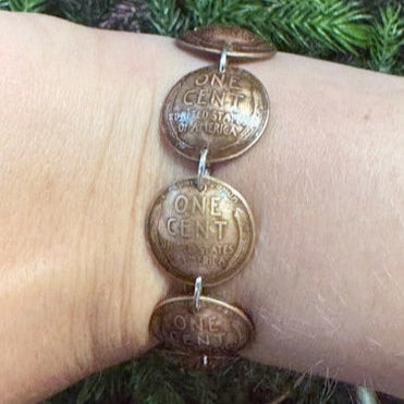 U.S. Wheat Penny Domed Coin Bracelet back on a wrist in front a pine tree. - Mountainstruck Coin Jewelry
