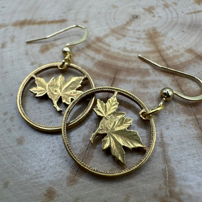 Canada Maple Leaf Hand Cut Coin Earrings 24k Gold Plated on wood background. - Mountainstruck Coin Jewelry