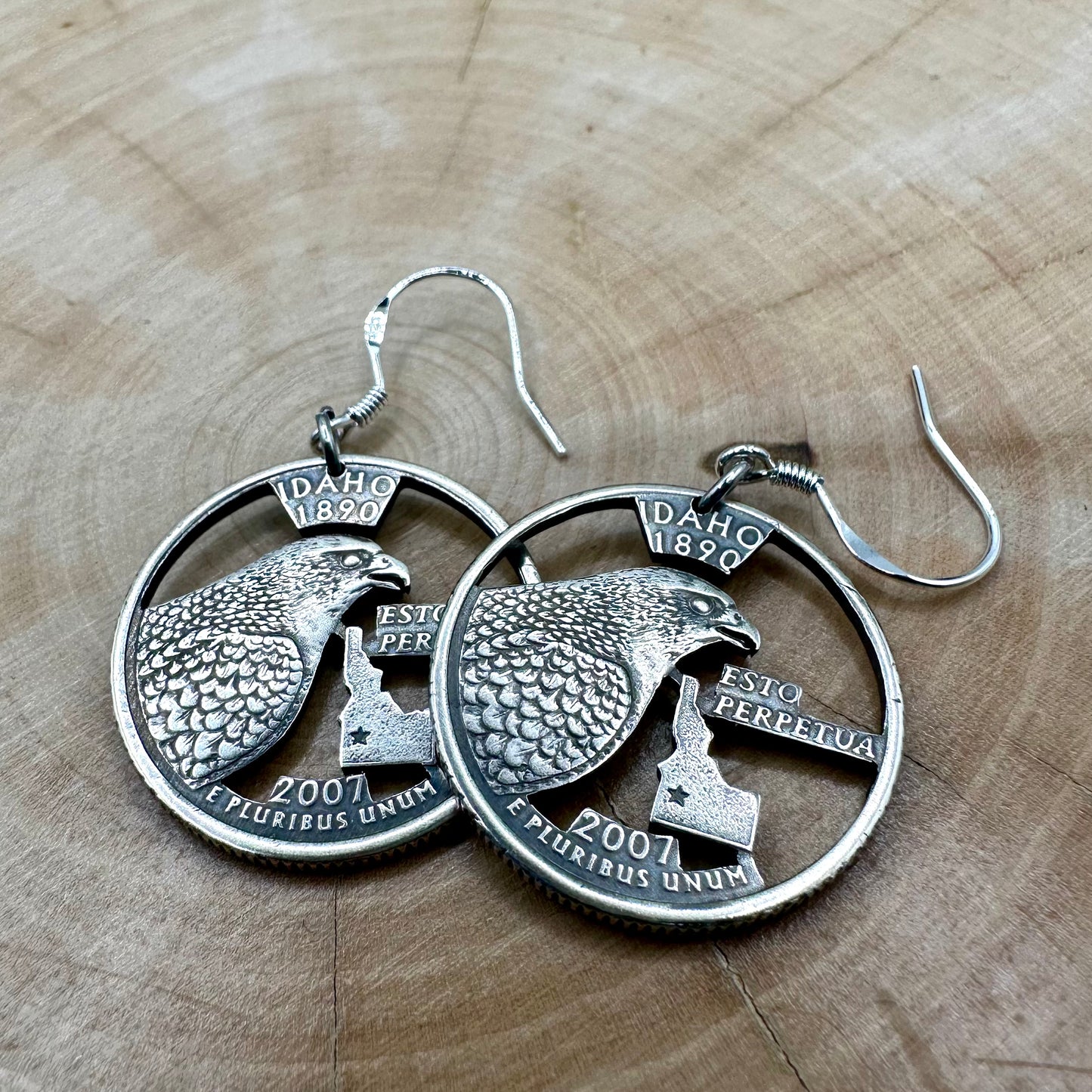 Idahome State Quarter Hand Cut Coin Earrings on a wood background. - Mountainstruck Coin Jewelry