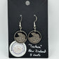 Tuatara New Zealand 5 Cents Hand Cut Coin Earrings on a black background with a round Mountainstruck Coin Jewelry sticker in bottom left corner.