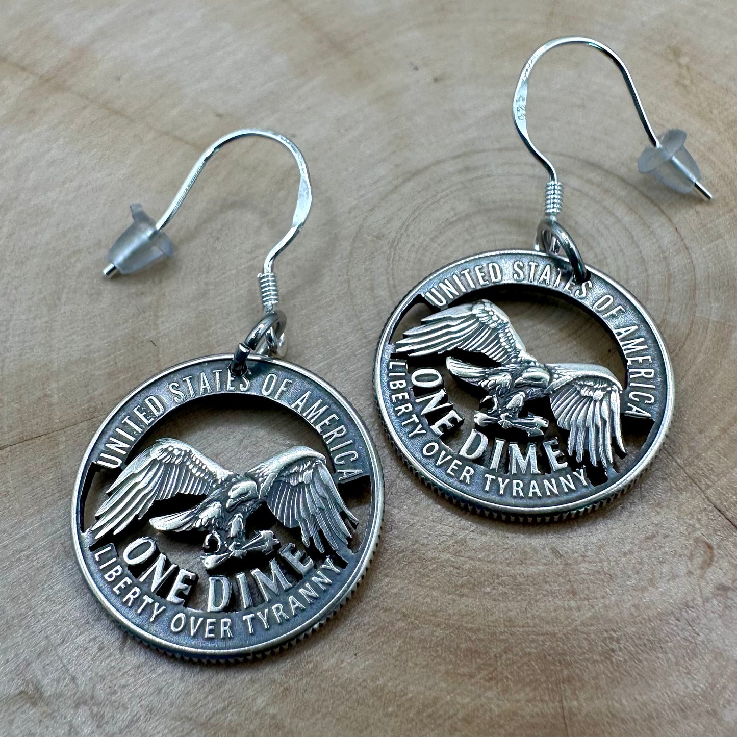 U.S. 2026 "Liberty over Tyranny" Dime Hand Cut Coin Earrings on a wood round. -Mountainstruck Coin Jewelry