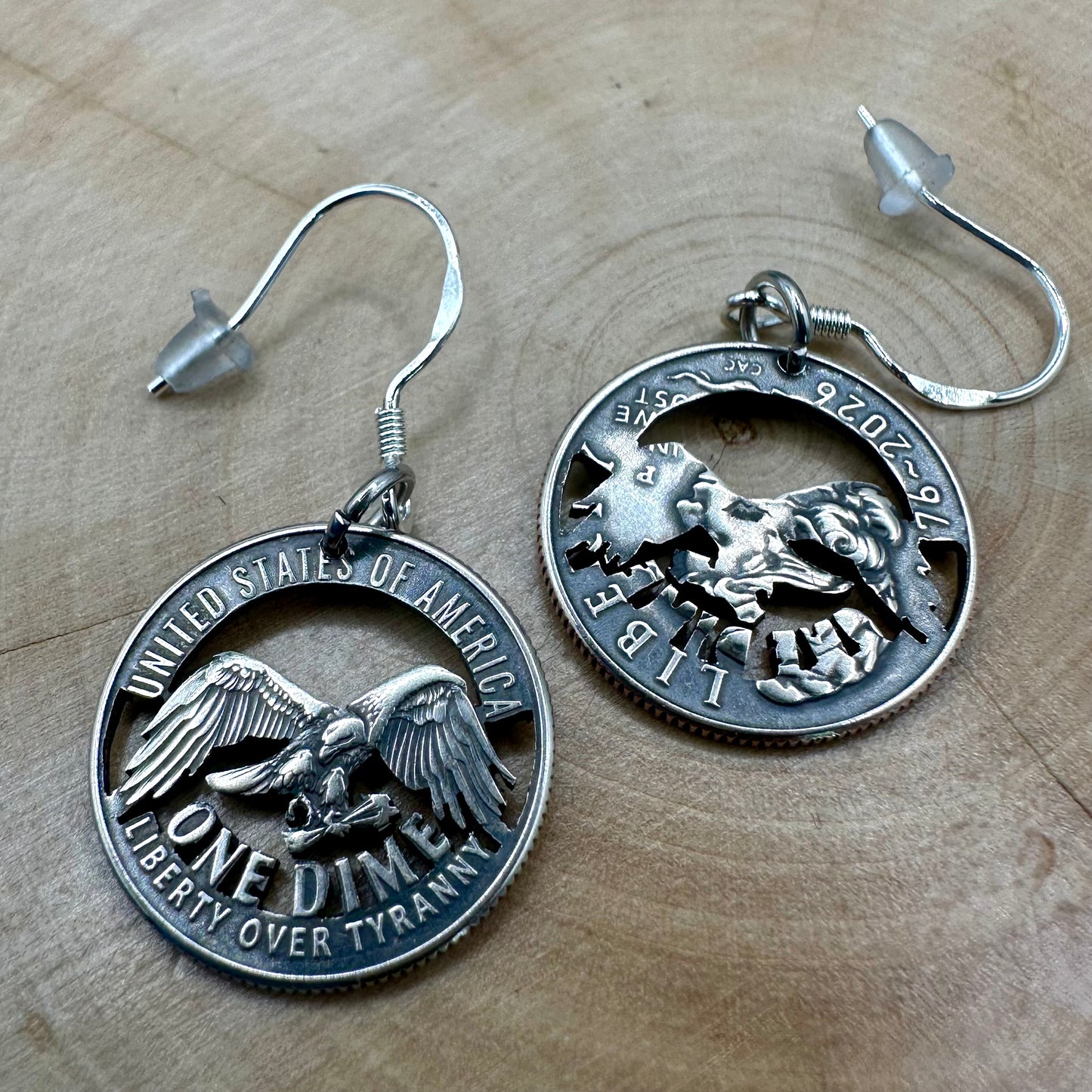 U.S. 2026 "Liberty over Tyranny" Dime Hand Cut Coin Earrings on a wood round. -Mountainstruck Coin Jewelry