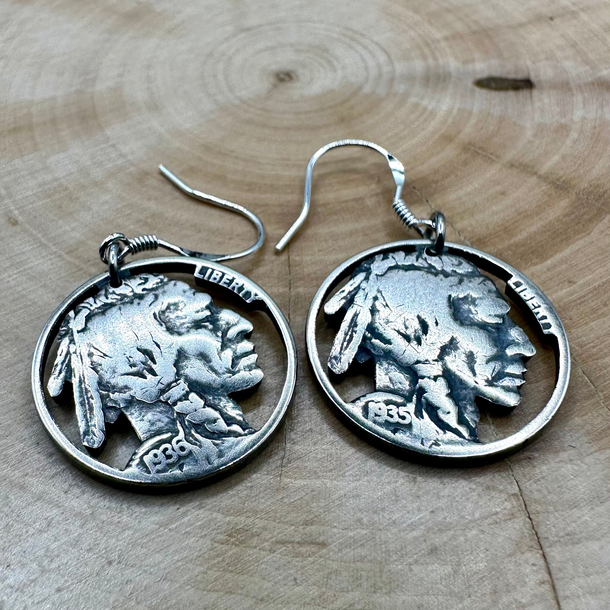 U.S. Buffalo Nickel Hand Cut Coin Earrings (Front) on a light wood round. - Mountainstruck Coin Jewelry