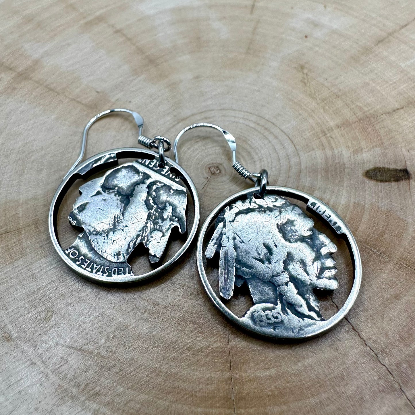 U.S. Buffalo Nickel Hand Cut Coin Earrings (Front) on a light wood round. - Mountainstruck Coin Jewelry